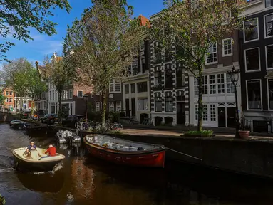 Sebuah kapal berlayar melewati kanal di kota Amsterdam, Belanda, Selasa (22/05/2024). (merdeka.com/Arie Basuki)
