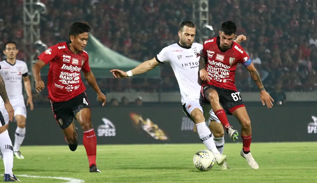 Striker Madura United, Aleksandar Rakic, berebut bola dengan gelandang Bali United, Stefano Lilipaly, pada laga Liga 1 2019 di Stadion Kapten I Wayan Dipta, Bali, Minggu (22/12). Bali kalah 0-2 dari Madura. (Bola.com/Aditya Wany)