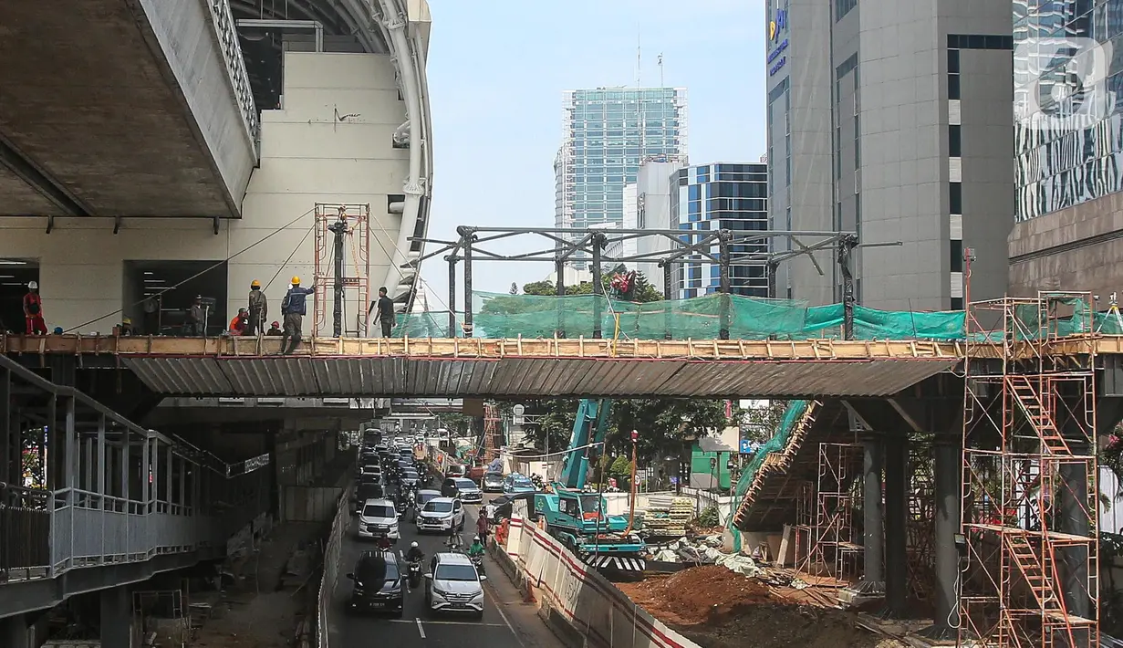 Pekerja menyelesaikan pembangunan JPO Stasiun LRT Rasuna Said di Jakarta, Senin (11/7/2022). Jadwal uji coba LRT Jabodebek batal dilakukan pada 17 Agustus 2022 dan direncakanan digelar pada Desember 2022 karena adanya kendala dalam skema pembiayaan pembangunan LRT Jabodebek. (Liputan6.com/Faizal Fanani)