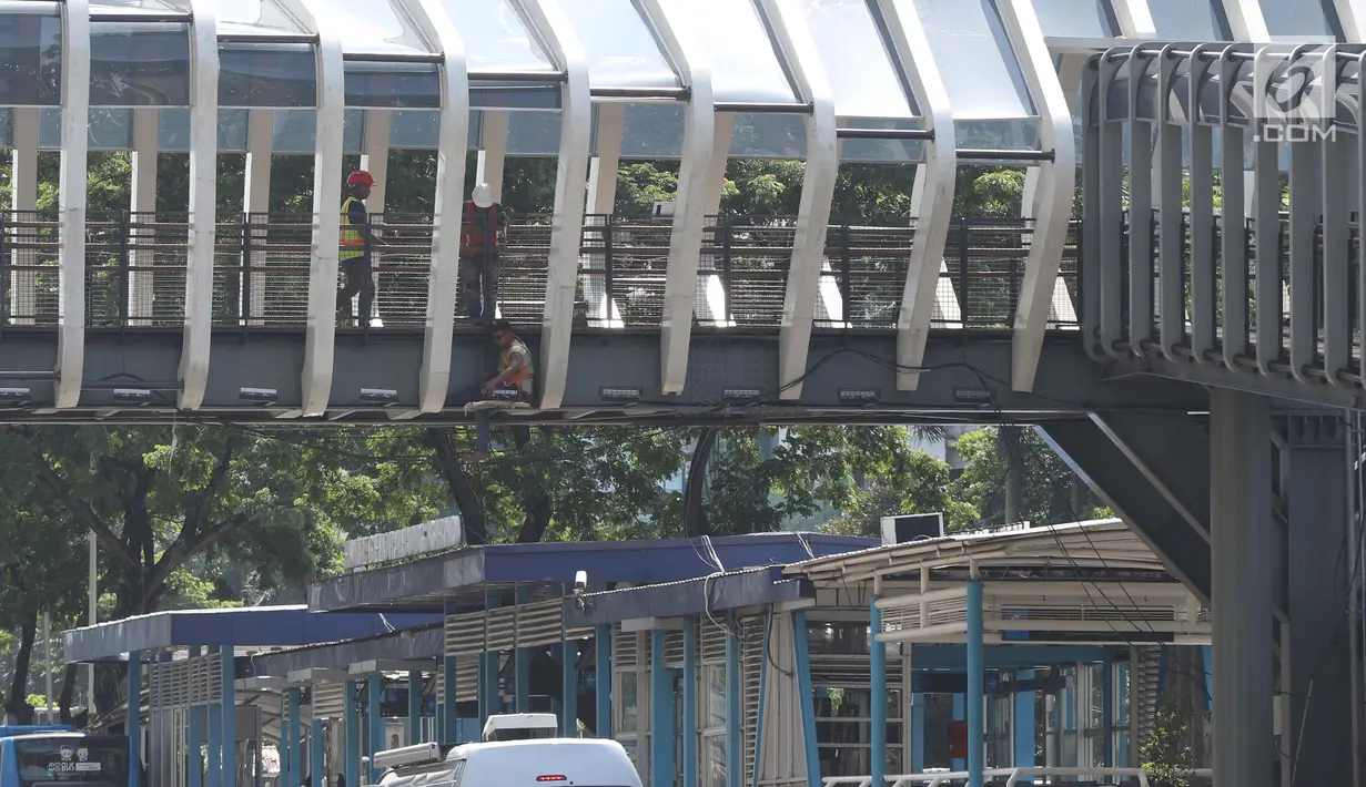 Pekerja beraktivitas mengerjakan proses revitalisasi JPO Gelora Bung Karno di Jalan Jenderal Sudirman, Jakarta, Jumat (22/2). Ditarget selesai pada Januari 2019, hingga kini proses revitalisasi masih terus berjalan. (Liputan6.com/Helmi Fithriansyah)