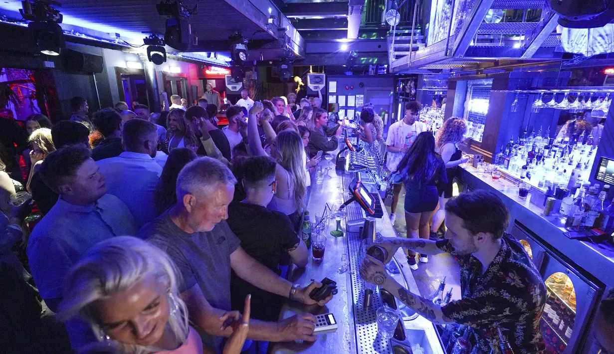 Orang-orang berkumpul di Bar Fiber di Leeds, setelah pembatasan resmi virus corona dicabut di Inggris pada tengah malam, Senin (19/7/2021). Kelab malam yang tutup sejak Maret 2020 akhirnya bisa dibuka kembali.  (Ioannis Alexopoulos/PA via AP)
