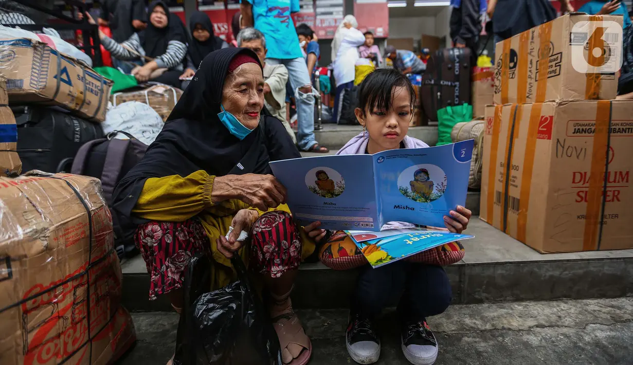 Anak-anak yang hendak ikut dalam perjalanan mudik membaca buku yang diberikan secara cuma-cuma oleh Badan Bahasa Kementerian Pendidikan, Kebudayaan, Riset, dan Teknologi (Kemendikbudristek) di Teriminal Kalideres, Jakarta, Selasa (2/4/2024). (Liputan6.com/Angga Yuniar)