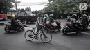 Pengendara motor dan sepeda melintas dekat kendaraan taktis TNI dan Polri saat penyekatan PPKM Darurat di kawasan Lampiri, Kalimalang, Jakarta, Senin (5/7/2021). Penyekatan ini dilakukan untuk membatasi pergerakan di perbatasan Jakarta guna memutus penyebaran COVID-19. (merdeka.com/Iqbal S. Nugroho)