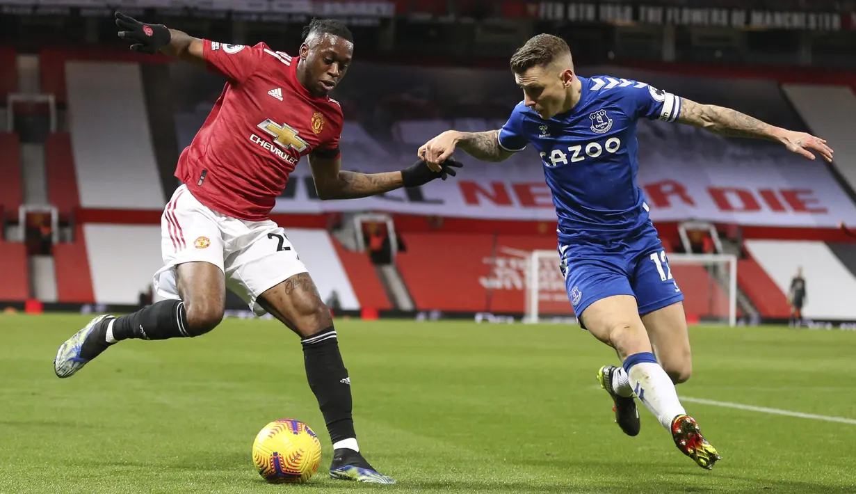 Bek Manchester United (MU), Aaron Wan-Bissaka bersaing dengan bek Everton, Lucas Digne pada laga pekan ke-23 Liga Inggris 2020/2021 di Old Trafford, Minggu dinihari WIB (7/2/2021). MU mampu bermain imbang 3-3 saat menjamu Everton. (Alex Pantling/Pool via AP)