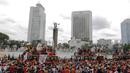 Suporter Persija Jakarta, The Jakmania, konvoi merayakan gelar Piala Liga 1 musim 2018 di Bundaran HI, Jakarta, Sabtu (15/12). Persija berhasil juara Liga 1 usai mengalahkan Mitra Kukar. (Bola.com/Yoppy Renato)