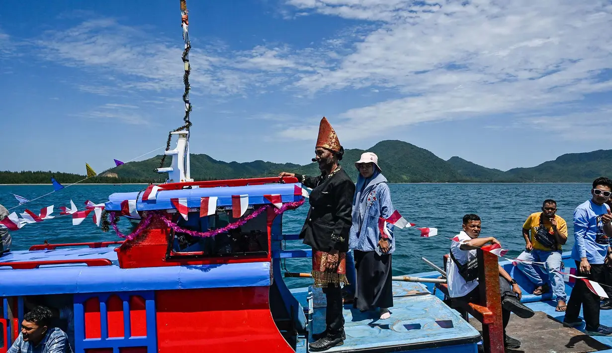 Nelayan yang tergabung dalam wilayah Panglima Laot Lok Kuala Cangkoi bersama warga mengikuti pawai kapal hias pada tradisi kenduri laut di Ulee Lheu, Banda Aceh, Aceh, Rabu (22/7/2026). (AFP/ Chaideer Mahyuddin)
