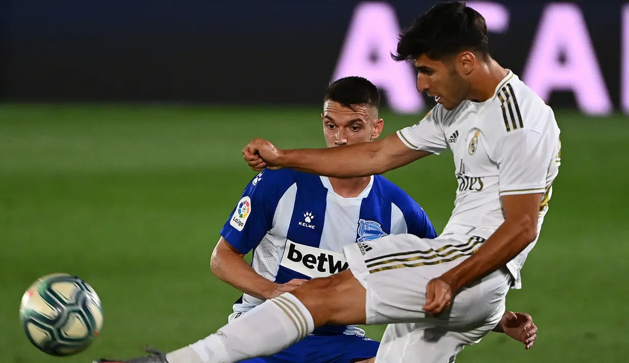 Gelandang Real Madrid, Marco Asensio, berebut bola dengan bek Alaves, Adrian Marin Gomez, pada laga lanjutan La Liga pekan ke-35 di Stadion Alfredo di Stefano, Sabtu (11/7/2020) dini hari WIB. Real Madrid menang 2-0 atas Alaves. (AFP/Gabriel Bouys)