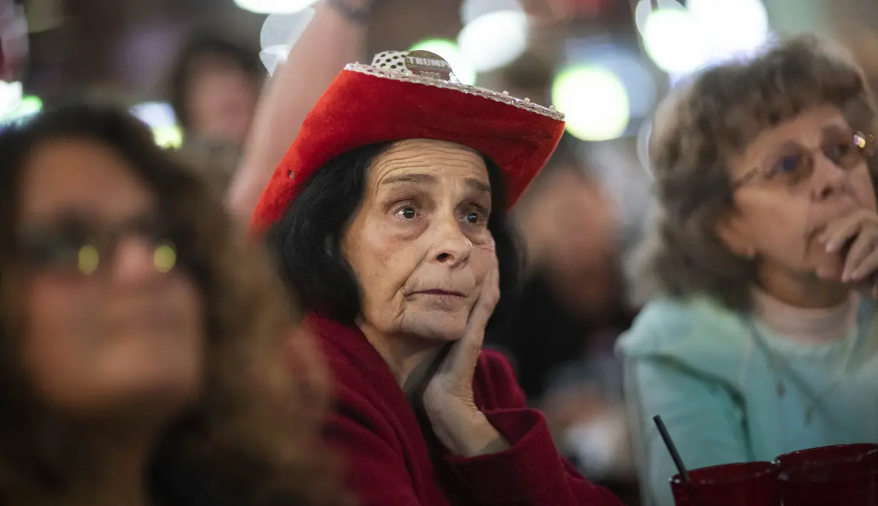 Lenore Kurek (tengah) menonton bersama sesama pendukung Presiden Donald Trump saat hasil pemilu disiarkan di televisi pada pesta tontonan di Shelby Township, Mich., Selasa (3/11/2020). (AP Photo / David Goldman)