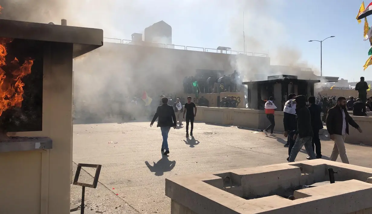 Para demonstran membakar tempat penerimaan tamu di dalam kompleks kedutaan besar AS, di Baghdad, Irak, Selasa (31/12/2019). Ribuan demonstran menyerbu kompleks Kedubes AS di Baghdad, Irak menghancurkan pintu utama dan membakar area penerimaan tamu. (AP Photo/Qassim Abdul-Zahra)