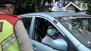Petugas memeriksa jumlah penumpang salah satu taksi saat penindakan PSBB di kawasan Menteng, Jakarta, Senin (13/4/2020). Aturan bagi pengendara saat PSBB berlangsung antara lain wajib mengenakan masker dan sarung tangan bagi pengendara motor. (merdeka.com/Iqbal S. Nugroho)