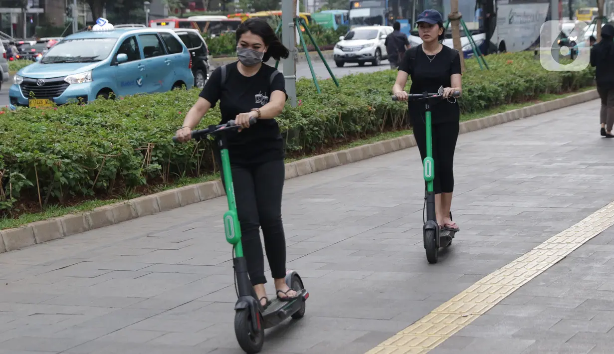 Pengguna otoped listrik Grabwheels melintas di trotoar Jalan Jenderal Sudirman, Jakarta, Kamis (14/11/2019). Pemprov DKI Jakarta melarang penggunaan otoped listrik di trotoar, Jembatan Penyeberangan Orang (JPO) serta pada pelaksanaan Hari Bebas Kendaraan. (Liputan6.com/Helmi Fithriansyah)
