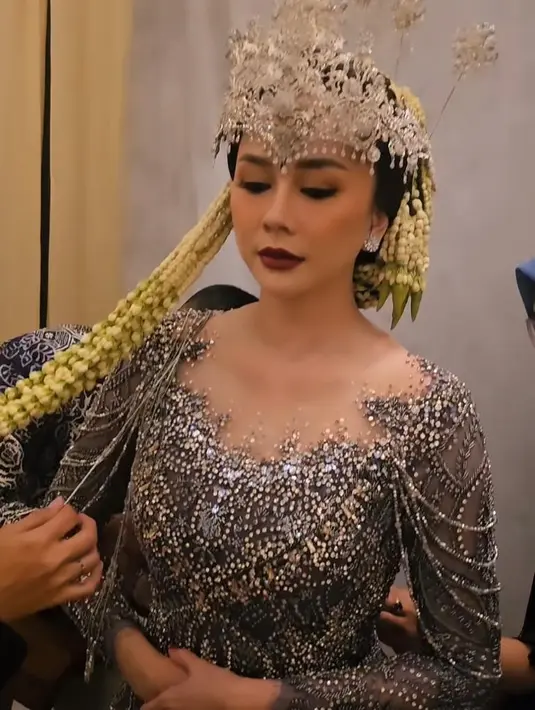 Serta pulasan makeup pengantin klasik yang berfokus pada riasan mata yang bold dan bibir merah merona. [@iniriezka]