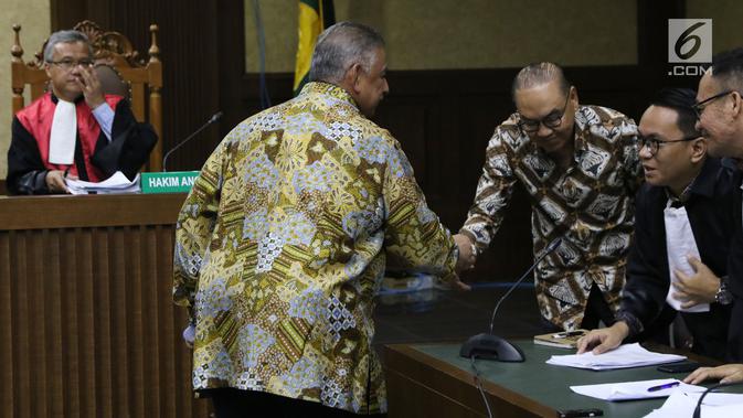 Dirut PT PLN (Persero), Sofyan Basir menyalami terdakwa kasus suap pembangunan PLTU Riau-1, Johannes Budisutrisno Kotjo usai memberi kesaksian pada sidang lanjutan di Pengadilan Tipikor, Jakarta, Kamis (25/10). (Liputan6.com/Helmi Fithriansyah)
