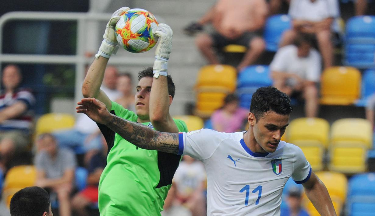 Kiper Timnas Ukraina, Andriy Lunin berebut bola dengan pemain Timnas Italia, Gianluca Scamacca pada laga Semifinal Piala Dunia U-20 di Gdynia, Polandia, 11 Juni 2019. Andriy Lunin keluar sebagai kiper terbaik pada ajang tersebut. Ia juga sukses mengantarkan Timnas Unkraina U-20 menjuarai Piala Dunia U-20 2019 setelah mengalahkan Korea Selatan dengan skor 3-1. (AFP/Alik Kepicz)