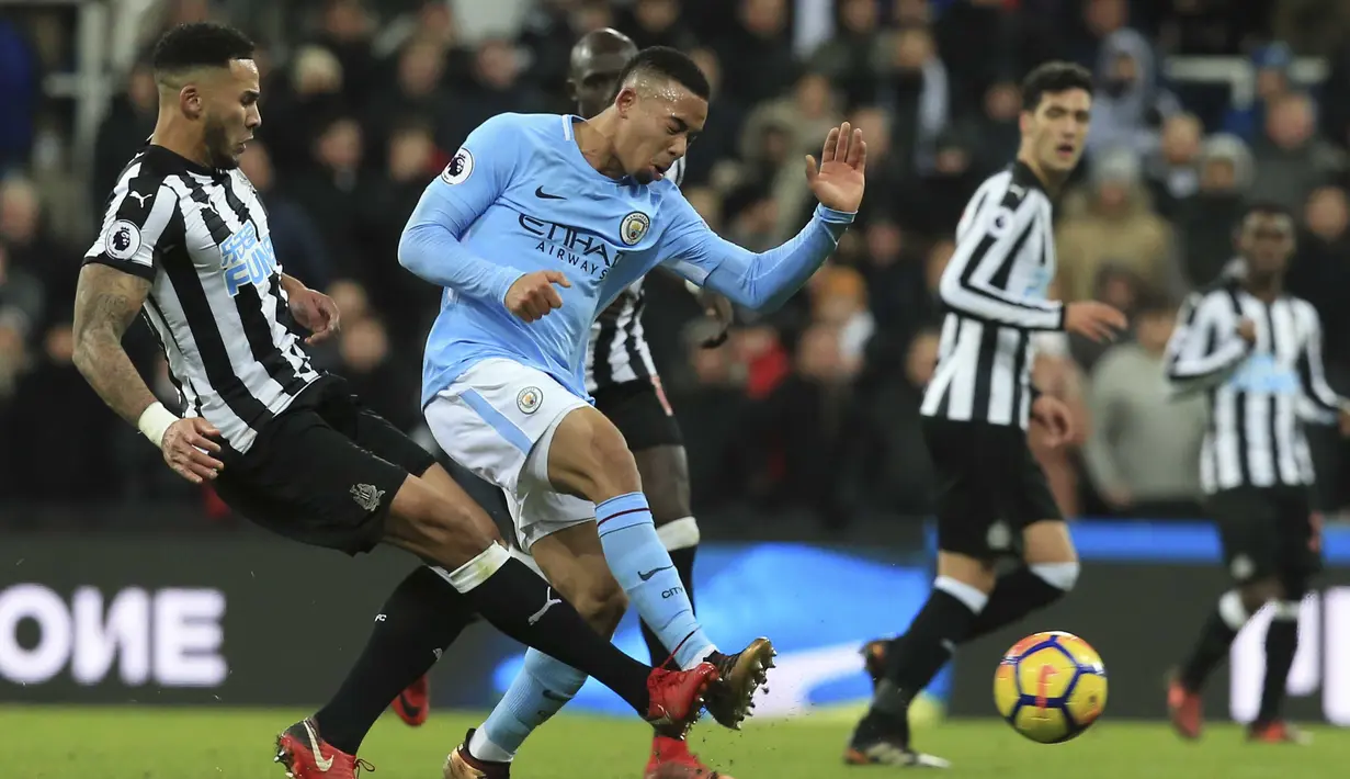 Pemain Newcastle United, Jamaal Lascelles (kiri) berebut bola dengan pemain Manchester City, Gabriel Jesus (kanan) pada lanjutan Premier League di St James' Park, Newcastle-upon-Tyne, (27/12/2017). Manchester City menang 1-0. (AFP/Lindsey Parnaby)