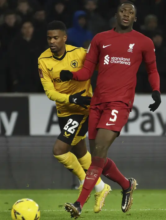Bek Liverpool Ibrahima Konate berebut bola dengan bek Wolverhampton Wanderers Nelson Semedo dalam partai replay putaran ketiga Piala FA 2022/2023 di Molineux Stadium, Rabu dini hari WIB (18/1/2023). Gol jarak jauh Harvey Elliott di menit ke-13 menjadi satu-satunya gol yang tercipta di laga ini. (AP Photo/Rui Vieira)