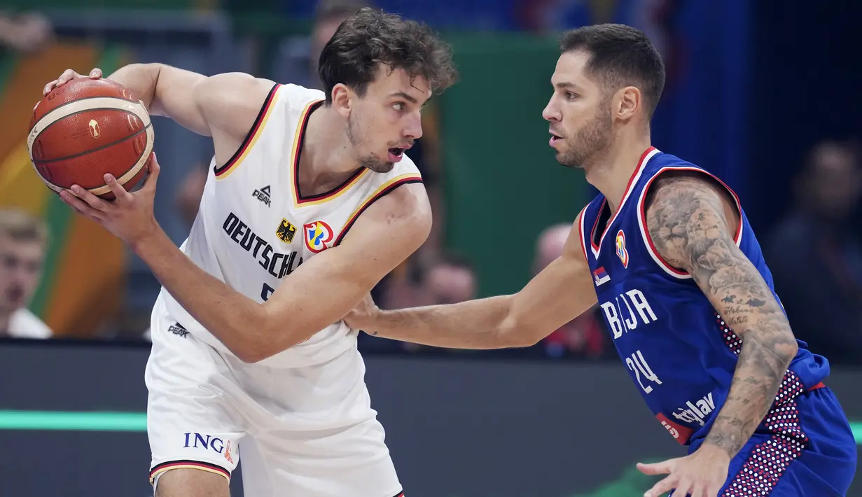 Pemain Timnas Basket Jerman, Franz Wagner (kiri), berusaha melewati hadangan guard Serbia, Stefan Jovic, dalam pertandingan final Piala Dunia FIBA 2023 yang berlangsung di Mall of Asia Arena, Pasay, Filipina, Minggu (10/9/2023) malam WIB. (AP Photo/Michael Conroy)