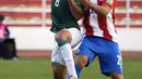 Pemain Bolivia Diego Bejarano (kiri) berebut bola dengan pemain Paraguay Oscar Romero pada pertandingan kualifikasi Piala Dunia 2022 di Stadion Hernando Siles, La Paz, Bolivia, Kamis (14/10/2021). Bolivia menang 4-0. (Javier Mamani/Pool via AP)
