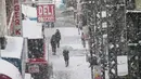 Pejalan kaki berjalan di tengah badai salju di sepanjang rel kereta di Broadway di distrik Brooklyn, New York (21/3). Badai salju yang melanda sebagian Amerika Serikat telah membawa salju dan angin kencang. (AP Photo / Mary Altaffer)