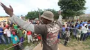 Wasit mengajak anak laki-laki muda masuk ring tinju di Chitungwiza, Zimbabwe (11/3). Setiap akhir pekan anak laki-laki Zimbabwe bertanding di atas ring tinju dan akan mendapatkan julukan Wafa Wafa. (AP Photo / Tsvangirayi Mukwazhi)