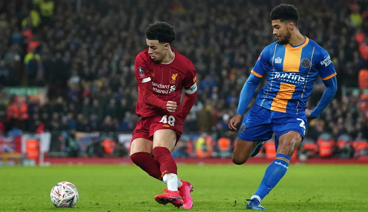 Pemain Liverpool Curtis Jones (kiri) duel bola dengan pemain Shrewsbury Town Josh Laurent pada pertandingan ulang babak keempat Piala FA di Anfield Stadium, Liverpool, Inggris, Selasa (4/2/2020). Liverpool menang 1-0. (AP Photo/Jon Super)