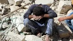 Seorang warga tertunduk usai serangan udara di distrik al-Fardous, Aleppo, Suriah, Rabu (12/10). Serangan udara terhadap kota yang dikuasai oleh pemberontak di Aleppo menewaskan sedikitnya 15 orang. (REUTERS/Abdalrhman Ismail)
