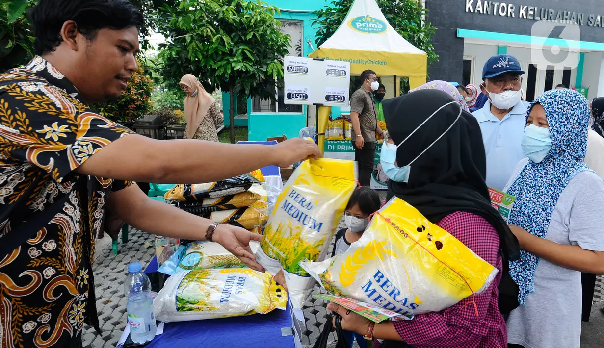 Petugas melayani warga yang membeli bahan kebutuhan pokok dengah harga di bawah harga eceran tertinggi (HET) saat kegiatan operasi pasar di Kantor Kelurahan Sawah, Tangerang Selatan, Banten, Kamis (29/9/2022). Dinas Perindustrian dan Perdagangan (Disperindag) Kota Tangerang Selatan menggelar operasi pasar di tujuh kecamatan dalam rangka penanganan inflasi sebagai dampak kenaikan harga bahan bakar minyak (BBM). (merdeka.com/Arie Basuki)