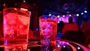 Dua minuman terlihat di atas meja saat seorang DJ tampil di Kafe Berlin di Madrid (17/1/2021). Dengan infeksi virus Corona harian mencapai rekor tertinggi setelah liburan Natal, beberapa wilayah Spanyol bergerak untuk semakin memperketat pembatasan pada kehidupan sosial. (AFP/Gabriel Bouys)