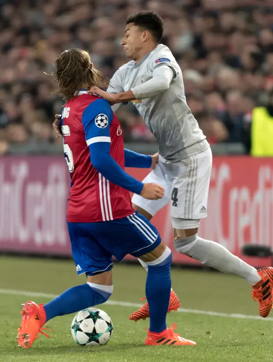 Pemain FC Basel, Michael Lang berebut bola dengan pemain Manchester United, Jesse Lingard pada matchday kelima Grup A Liga Champions di Stadion St Jakob Park, Rabu (22/11). Manchester United takluk 0-1 di markas Basel. (Georgios Kefalas/Keystone via AP)
