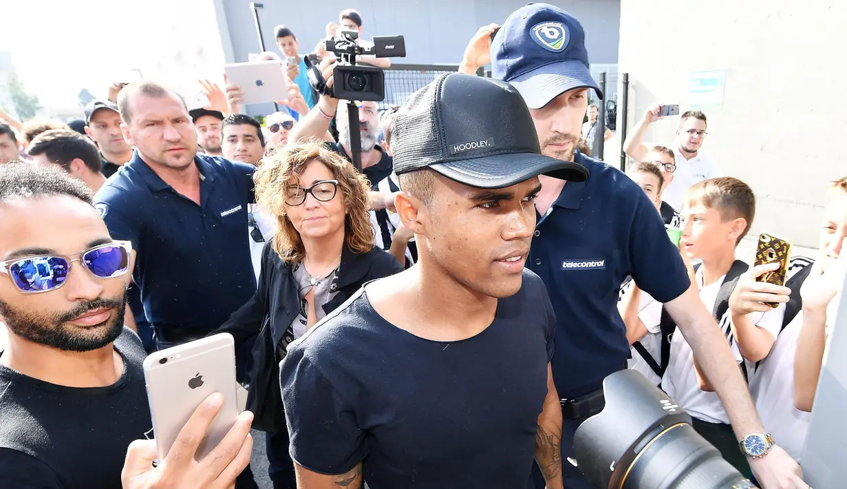 Gelandang Bayern Munchen, Douglas Costa, dikerubuti wartawan saat akan menjalani tes medis bersama Juventus di Juventus Medical Center, Turin, Rabu (12/7/2017). (EPA/Alessandro Di Marco)