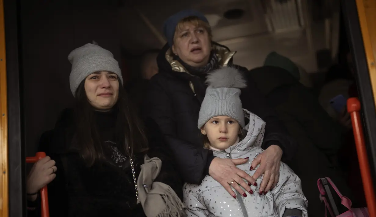 Reaksi seorang wanita dengan putrinya dan ibunya ketika mengucapkan selamat tinggal kepada suaminya saat naik kereta menuju Lviv di stasiun Kiev, 3 Maret 2022. Sejumlah keluarga terpaksa terpisah, dengan mayoritas pria tetap tinggal di Ukraina mempertahankan negaranya. (AP Photo/Emilio Morenatti)