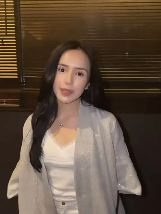 Beby Tsabina mengenakan outer panjang lengan pendek abu-abu dipadukan inner tank top putih dipadukan celana putihnya. [@rklopperr]