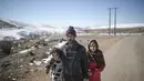 Al Hassan (42) berpose bersama putrinya saat mereka berjalan ke rumah mereka di desa Amazigh Timahdite di Atlas Tengah, dekat Azrou, Maroko (4/12/2021). Suku nomaden Amazigh yang tinggal di sini bergantung pada domba yang merumput di hutan rimbun di sekitar desa. (AP Photo/Mosa'ab Elshamy)