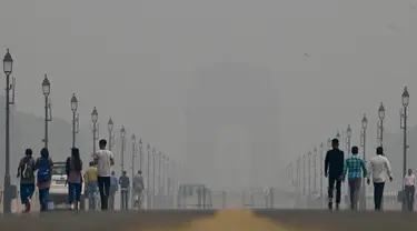 Orang-orang berjalan di sepanjang Jalur Kartavya di dekat Gerbang India di tengah kondisi kabut asap yang tebal di New Delhi pada tanggal 3 November 2023. (ARUN THAKUR/AFP)