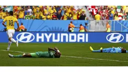 Dua pemain Pantai Gading tergeletak usai gelandang Kolombia, James Rodriguez (10) mencetak gol buat Los Cafeteros di laga penyisihan Piala Dunia 2014 Grup C di Stadion National Mane Garrincha, Brasil, (19/6/2014). (REUTERS/Paul Hanna)