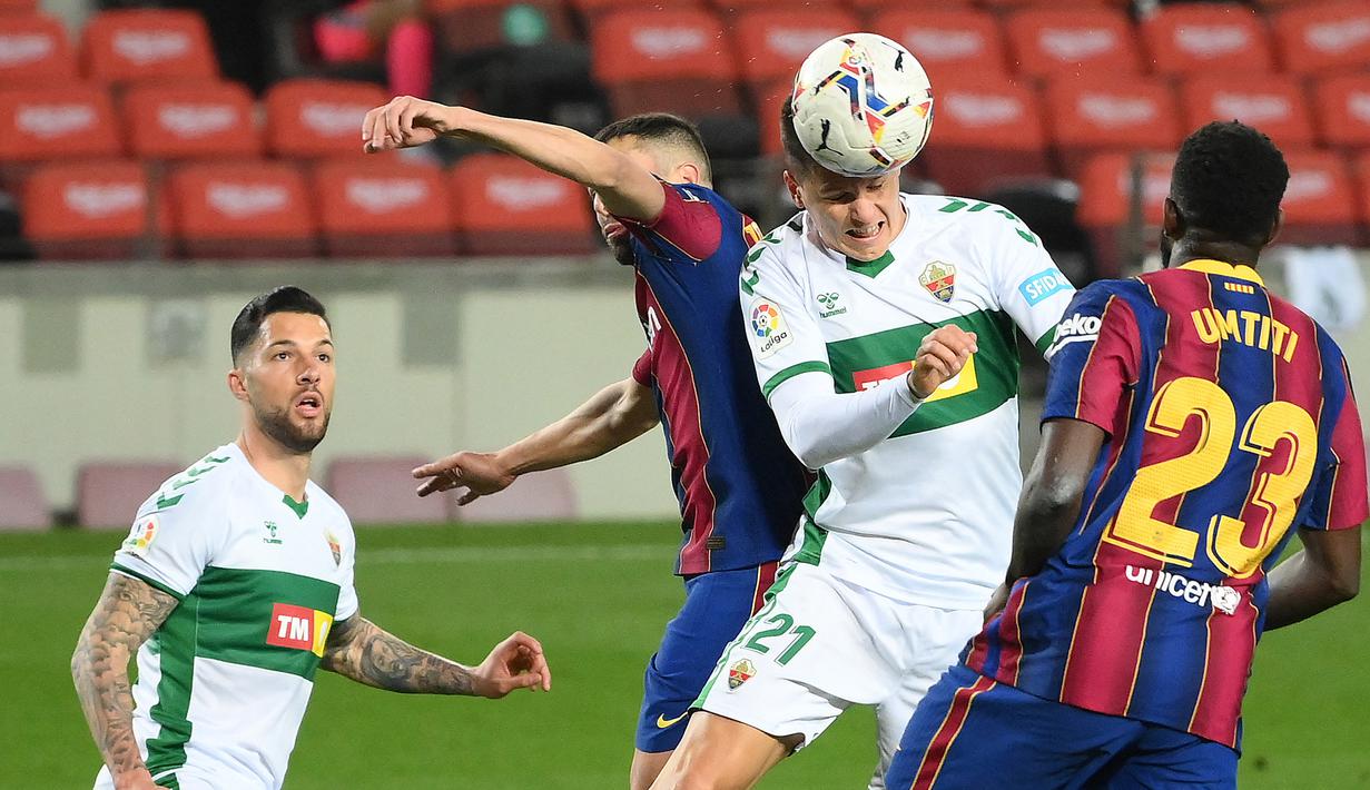 Striker Elche, Guido Carrillo (kedua dari kanan) melepaskan sundulan di mulut gawang Barcelona dalam laga lanjutan Liga Spanyol 2020/21 pekan ke-24 di Camp Nou Stadium, Barcelona, Rabu (24/2/2021). Elche kalah 0-3 dari Barcelona. (AFP/Lluis Gene)