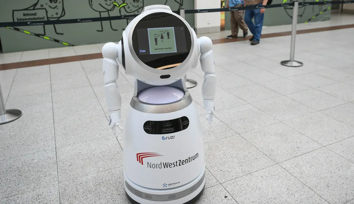 Para pengunjung berjalan melewati sebuah robot pintar yang menjelaskan tentang langkah-langkah pencegahan COVID-19 di sebuah pusat perbelanjaan di Frankfurt, Jerman, pada 12 September 2020. (Xinhua/Lu Yang)