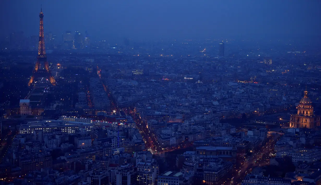 Lansekap kota Paris saat sore hari dari atap gedung pencakar langit "The Tour Montparnasse" memperlihatkan Menara Eiffel, Senin (8/1). Pemandangan bangunan klasik yang bersejarah pun menjadi panorama kota yang sangat menarik. (CHRISTOPHE SIMON/AFP)