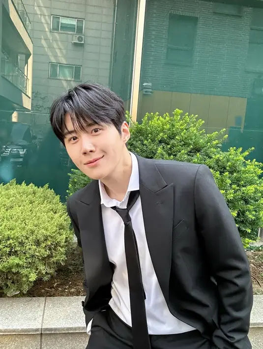 Kim Seon Ho tampil formal dengan gaya messy mengenakan setelan jas hitam dan kemeja putih. Dilengkapi dengan dasi panjang yang longgar [@seonho_kim]