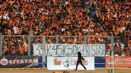 Suporter Persija membentangkan spanduk protes kenaikan harga tiket dibandingkan dengan prestasi tim Macan Kemayoran saat laga Persija melawan Persela di Stadion GBK Jakarta, Minggu (1/3/2015). (Liputan6.com/Helmi Fithriansyah)
