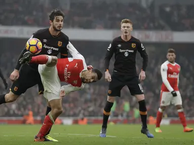 Pemain Arsenal, Francis Coquelin (tengah) berusaha merebut bola dari hadangan pemain Hull City, Andrea Ranocchia pada lanjutan Premier League di Emirates Stadium, London, (11/2/2017). Arsenal menang 2-0.  (AP/Matt Dunham)