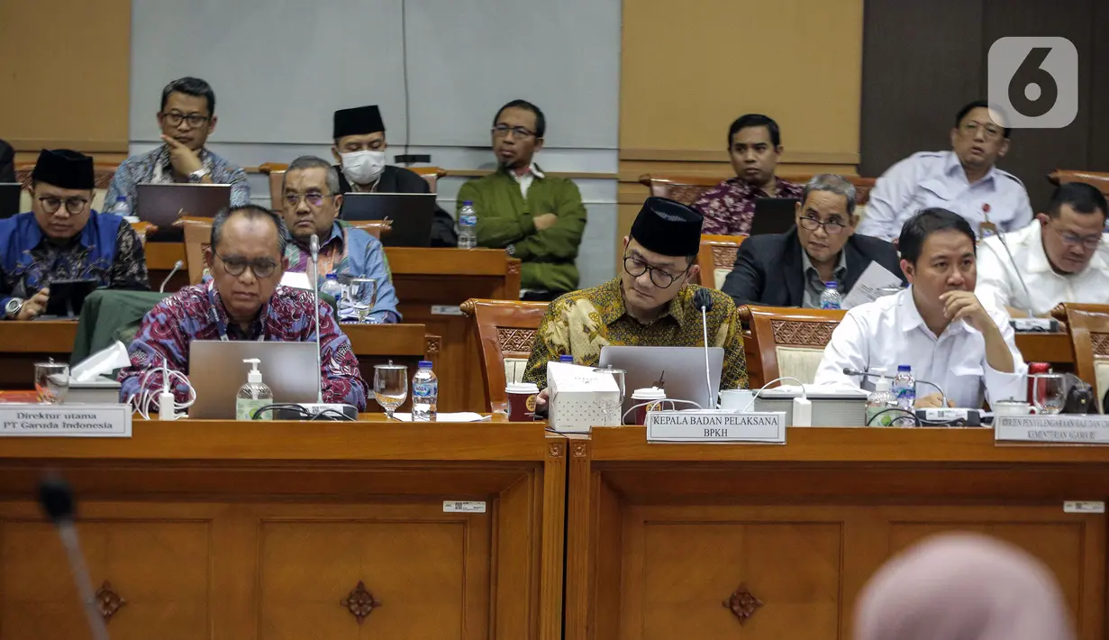 Dirjen Penyelenggaraan Haji dan Umrah (PHU) Hilman Latief (kanan) dan Kepala Badan Pengelola Keuangan Haji (BPKH) Fadlul Imansyah (tengah) menyampaikan paparan saat rapat dengar pendapat bersama Komisi VIII DPR di Kompleks Parlemen, Senayan, Jakarta, Selasa (14/2/2023). Pengumuman terkait besaran biaya haji terpaksa ditunda hingga besok lantaran pemerintah bersama Panja Komisi VIII DPR masih belum menemui kesepakatan. (Liputan6.com/Faizal Fanani)