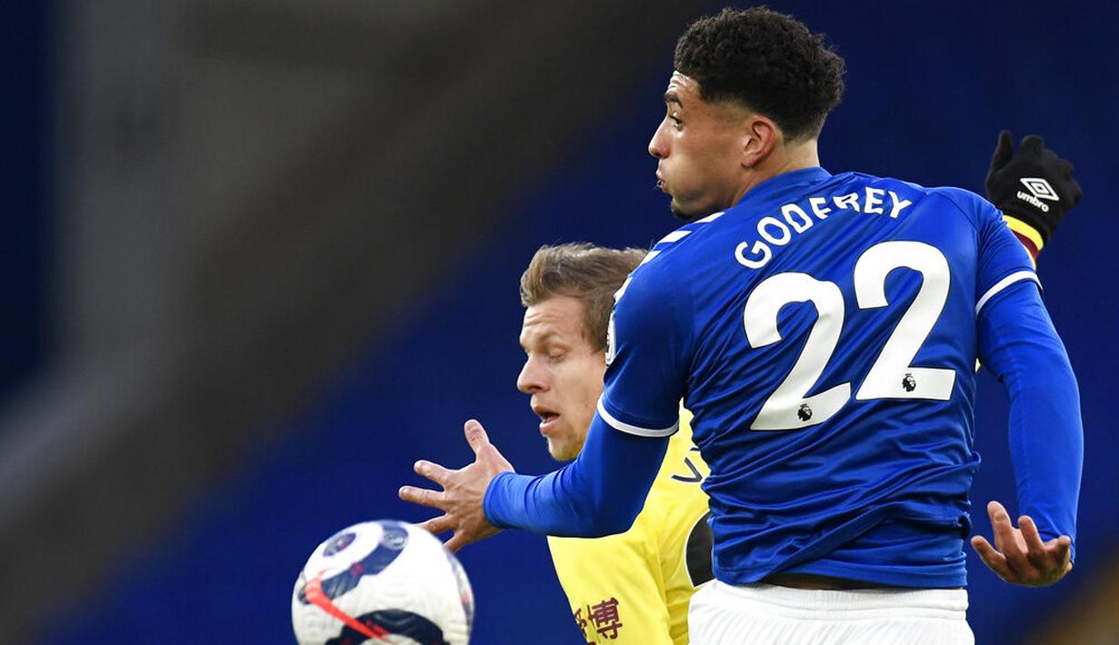 Pemain Everton, Ben Godfrey, duel udara dengan pemain Burnley, Matej Vydral, pada laga Liga Inggris di Stadion Goodison Park, Sabtu (13/3/2021). Burnley menang dengan skor 2-1. (Peter Powell/Pool via AP)