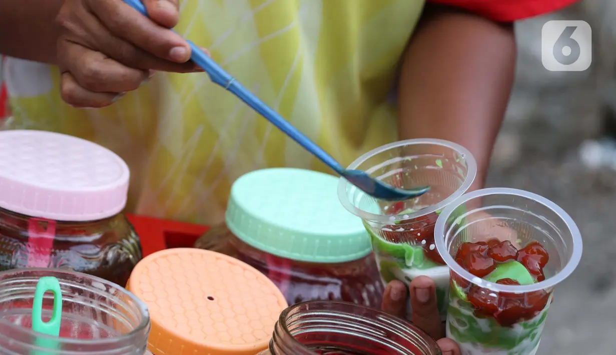 Pedagang meracik minuman untuk berbuka puasa di kawasan Bendungan Hilir, Jakarta, Sabtu (25/4/2020). Meski ditengah pandemi virus Covid-19, masyarakat masih antusias berburu penganan berbuka puasa dengan tetap menerapkan pola jaga jarak dan memakai masker. (Liputan6.com/Helmi Fithriansyah)