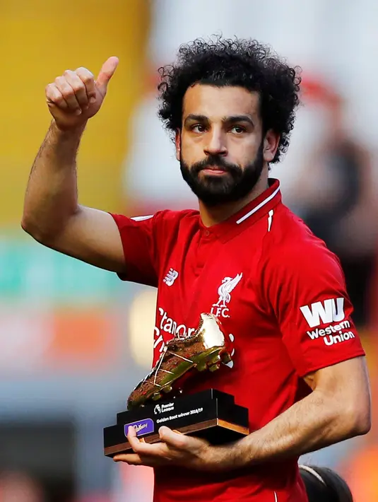 Pemain Liverpool Mohamed Salah menyapa para supoter sambil memegang piala Sepatu Emas Liga Inggris usai menghadapi Wolverhampton Wanderers di di Stadion Anfield, Liverpool, Inggris, Minggu (12/5/2019). Liverpool gagal meraih gelar juara Liga Inggris. (Reuters/Phil Noble)