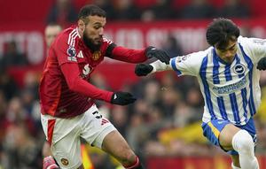 Bek Manchester United, Noussair Mazraoui beradu kecepatan melawan gelandang Brighton, Kaoru Mitoma. (c) AP Photo/Dave Thompson