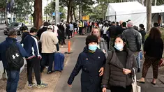 Warga Sydney mengantre di luar pusat vaksinasi Covid-19 di Sydney, Australia, Kamis (24/6/2021). Sebagian besar warga Sydney dilarang meninggalkan kota untuk menghentikan penyebaran virus corona Covid-19 varian Delta yang sangat menular ke wilayah lain. (SAEED KHAN / AFP)