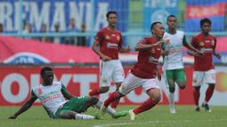 Gelandang PS TNI, Ibrahim Conteh, melakukan tekel keras saat melawan Bhayangkara FC pada laga Piala Presiden 2017 di Stadion Kanjuruhan, Malang, Sabtu (11/7/2017). Bhayangkara FC menang 2-1 atas PS TNI.(Bola.com/Reza Bachtiar)