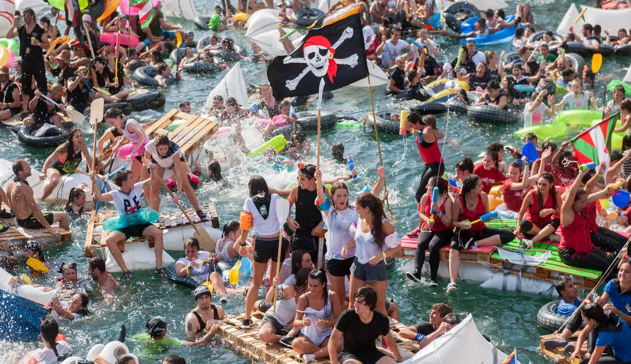 Ribuan orang berdatangan mendayung perahu rakitan buatan mereka di pelabuhan kota Basque San Sebastian utara selama acara "Abordaje", yang disebut oleh "Donostiako Piratak" (Pirates of San Sebastian), (12/8). (AFP Photo/Gari Garaialde)