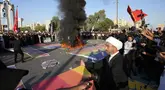 Pendukung pemimpin Syiah Moqtada Sadr membakar bendera pelangi saat demonstrasi di depan Kedutaan Besar Swedia, Baghdad, Irak, Jumat (30/6/2023). Aksi tersebut dilakukan sebagai bentuk protes atas pembakaran Alquran di Swedia. (AP Photo/Hadi Mizban)
